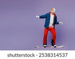 Full body side view smiling happy man he wear blue windbreaker jacket ski goggles mask hat snowboarding look aside spend extreme weekend winter season in mountains isolated on plain purple background