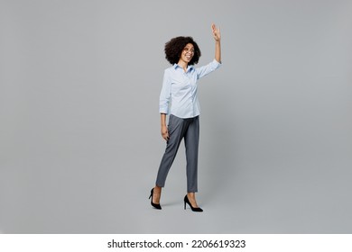 Full Body Side View Smiling Fun Young Employee Business Corporate Lawyer Woman Of African American Ethnicity In Classic Formal Shirt Work In Office Walking Go Waving Hand Isolated On Grey Background