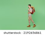 Full body side view young mountaineer traveler white man carry backpack stuff mat walk isolated on plain green background. Tourist leads active healthy lifestyle. Hiking trek rest travel trip concept