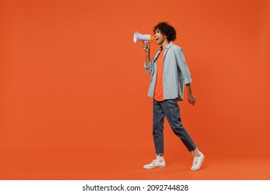 Full body side view young student black man 20s wear blue shirt t-shirt hold scream in megaphone announces discounts sale Hurry up isolated on plain orange background studio. People lifestyle concept - Shutterstock ID 2092744828
