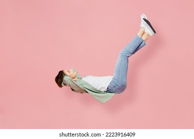 Full body side view young happy woman 20s she wear green shirt white t-shirt fly up hover over air fall down isolated on plain pastel light pink background studio portrait. People lifestyle concept - Shutterstock ID 2223916409