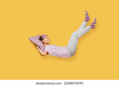 Full body side view young woman she wears purple pyjamas jam sleep eye mask rest relax at home fly up hover over air fall down on pillow isolated on plain yellow background studio. Night nap concept - Shutterstock ID 2260074595