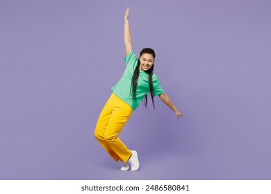 Full body side view young woman of African American ethnicity with dreadlocks wear green t-shirt casual clothes with outstretched hands isolated on plain pastel purple background. Lifestyle concept - Powered by Shutterstock