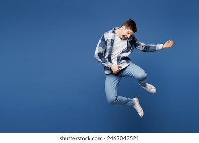 Full body singer happy young man he wear shirt white t-shirt casual clothes jump high pov play air guitar on stage sing song isolated on plain blue cyan background studio portrait. Lifestyle concept - Powered by Shutterstock