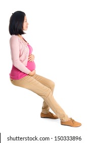 Full Body Six Months Pregnant Asian Woman Sitting On Transparent Chair, Side Or Profile View,  Isolated On White Background.