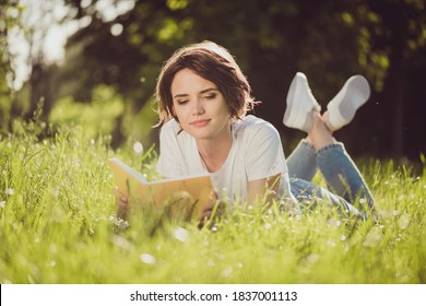 Full Body Size Photo Of Charming Lovely Cute Lady Smiling Reading Nice Romantic Novel Textbook Lying Grass In Harmony World Nature Resting Wear Jeans Sneakers White Shirt Outside