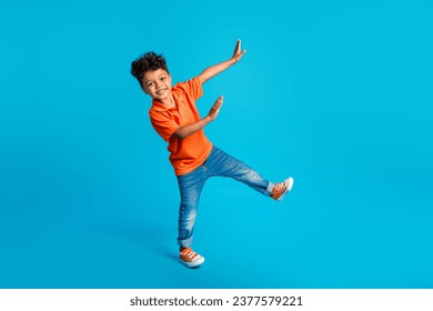 Full body size photo of dance cool little boy showing his arms dab carefree weekend positive mood disco isolated on blue color background - Powered by Shutterstock