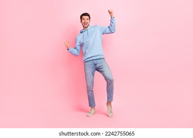 Full body size photo of excited man win his bet victory football team raise fists up hooray celebrate extra reward isolated on pink color background - Powered by Shutterstock