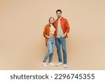Full body smiling happy cheerful fun cool young couple two friends family man woman wear casual clothes together looking camera hugging isolated on pastel plain beige color background studio portrait
