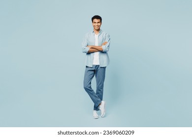 Full body smiling happy cheerful young man of African American ethnicity he wearing shirt casual clothes hold hands crossed folded isolated on plain pastel light blue cyan background studio portrait - Powered by Shutterstock