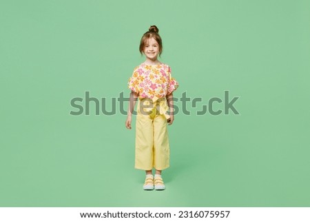 Full body smiling happy fun cheerful little child kid girl 6-7 years old wear casual clothes look camera isolated on plain pastel green background studio. Mother's Day love family lifestyle concept