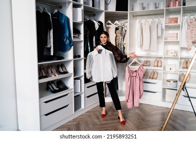 Full Body Of Stylish Woman Smiling And Looking Forward While Standing In Walk In Closet And Picking Attire At Home