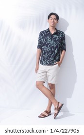 Full Body Summer Man Casual Wearing New Stylish Plant ,leaves Printed Long Sleeve Shirts With White Pants Short And Flip Flop Posing With Shadow