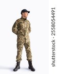 Full body Ukrainian soldier in military uniform looking away on white background.