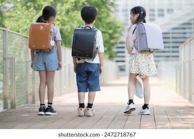 Full body without multiple faces behind school bags of elementary school students going to and from school	