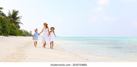 Full body woman with daughter and son walking on sandy beach near sea on sunny summer day on resort - Powered by Shutterstock