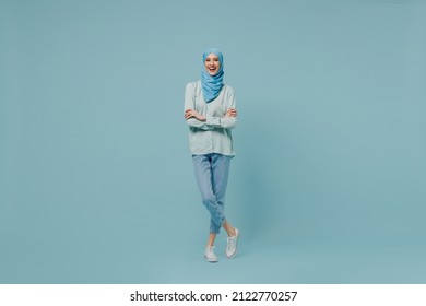 Full body young arabian asian muslim woman in abaya hijab hold hands crossed folded look camera isolated on plain blue background studio portrait. People uae middle eastern islam religious concept. - Shutterstock ID 2122770257