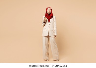 Full body young Arabian Asian Muslim woman wear red abaya hijab suit clothes hold delivery craft paper brown cup coffee to go isolated on plain beige background studio UAE middle eastern Islam concept - Powered by Shutterstock