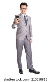 Full Body Of A Young Asian Business Man Using Smart Phone, Texting And Looking At The Phone With A Smile On His Face, Isolated On White Background.