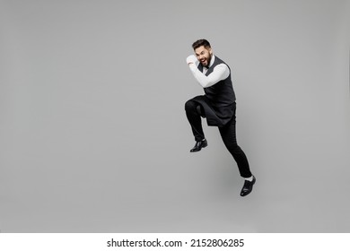 Full Body Young Barista Male Waiter Butler Man 20s Wear White Shirt Vest Elegant Uniform Work At Cafe Jump High Hurrying Up Run Isolated On Plain Grey Background Studio. Restaurant Employee Concept