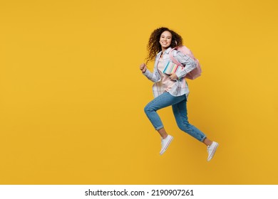 Full body young black teen girl student she wear casual clothes backpack bag jump high look camera run fast hurrying isolated on plain yellow color background. High school university college concept - Shutterstock ID 2190907261
