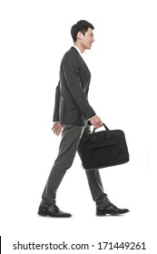 Full Body Young Business Man Holding A Laptop Bag Walking In Studio