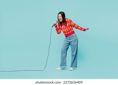 Full body young caucasian woman wear bright casual clothes sing song in microphone at karaoke club spread hand isolated on plain pastel light blue cyan background studio portrait. Lifestyle concept - Powered by Shutterstock