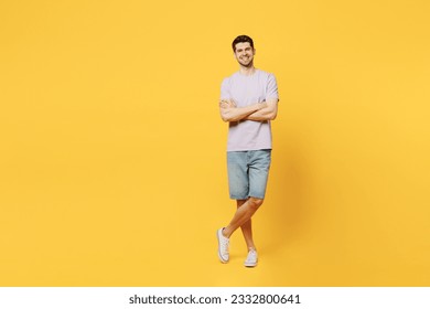 Full body young cheerful happy fun smiling man he wear light purple t-shirt casual clothes look camera hold hands crossed folded isolated on plain yellow background studio portrait. Lifestyle concept - Powered by Shutterstock