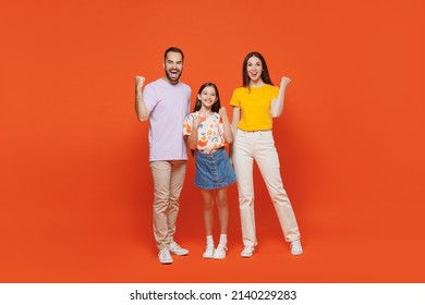 Full Body Young Cool Happy Parents Mom Dad With Child Kid Daughter Teen Girl In Basic T-shirts Doing Winner Gesture Celebrate Isolated On Yellow Background. Family Day Parenthood Childhood Concept.