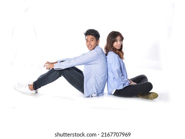 Full Body Young Couple Back To Back Sitting Together Posing In Studio

