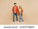 Full body young couple two friends family man woman wear casual clothes together point thumb finger aside indicate on workspace area copy space mock up isolated on pastel plain beige color background