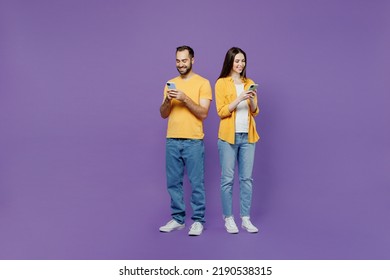 Full body young couple two friends family man woman together in yellow casual clothes hold in hand use mobile cell phone browsing internet chatting online isolated on plain violet background studio - Powered by Shutterstock