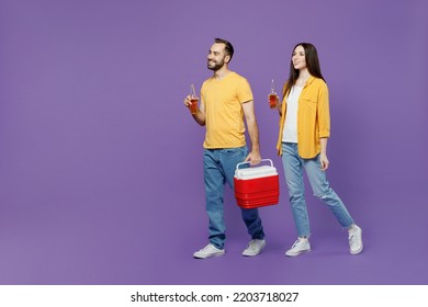 Full Body Young Couple Two Friends Family Man Woman Together Wear Yellow Clothes Hold Red Box Freezer Cooler Refrigerator Bottle Drink Beer Walk Go Isolated On Plain Violet Background Studio Portrait