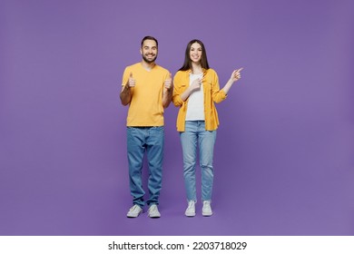 Full body young couple two friends family man woman together in yellow casual clothes point index finger aside on workspace area mock up copy space isolated on plain violet background studio portrait - Shutterstock ID 2203718029