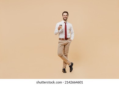 Full Body Young Employee Business Man Corporate Lawyer 20s Wear White Shirt Red Tie Glasses Work In Office Hold Takeaway Delivery Craft Paper Brown Cup Coffee To Go Isolated On Plain Beige Background