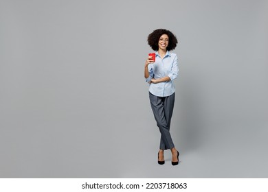 Full Body Young Employee Business Corporate Lawyer Woman Of African American Ethnicity In Formal Shirt Work In Office Hold Takeaway Delivery Red Plastic Cup Coffee To Go Isolated On Grey Background