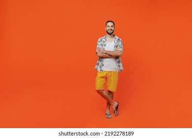 Full body young fun tourist man 20s wear beach shirt travel abroad on weekends hold hands crossed folded isolated on plain orange background studio portrait. Summer vacation sea rest sun tan concept