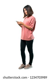 Full Body Of  Young Girl With Pink Shirt Sending A Message Or Email With The Mobile. Ideal For Use In Architectural Designs