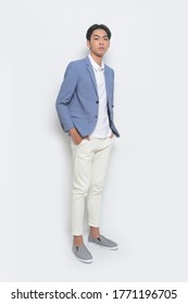 Full Body Young Handsome Man Wearing In Blue Suit With Polo Shirt And White Jeans Pants And Gray  Casual Shoes With And Holds Pockets

