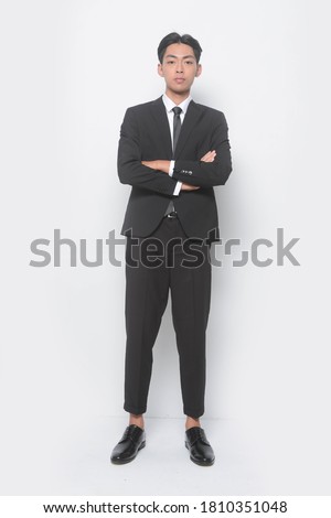 Full body Young handsome man with wearing suit with white shirt with pants and black leather shoes with arms crossed in studio