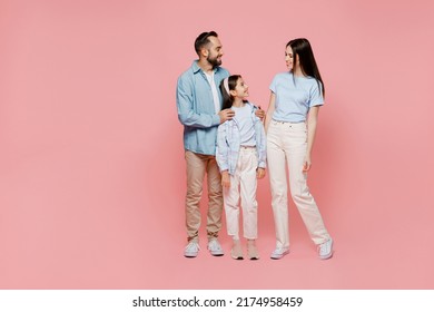 Full body young happy caucasian smiling fun cool parents mom dad with child kid daughter teen girl in blue clothes look to each other isolated on plain pastel light pink background. Family day concept - Powered by Shutterstock