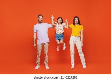 Full Body Young Joyful Fun Cool Happy Parents Mom Dad With Child Kid Daughter Teen Girl In Basic T-shirts Hold Hands Jump High Isolated On Yellow Background. Family Day Parenthood Childhood Concept.