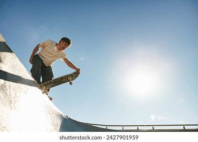Full body of young male skater in casual outfit doing trick on skateboard riding in skate park - Powered by Shutterstock