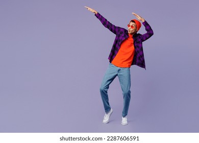Full body young man of African American ethnicity wear casual shirt orange hat doing dab hip hop dance hands move gesture youth sign isolated on plain pastel purple color background studio portrait