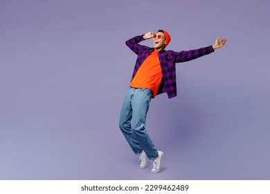 Full body young man of African American ethnicity wear casual shirt orange hat stand on toes leaning back with outstretched hand dance isolated on plain pastel purple color background studio portrait - Powered by Shutterstock