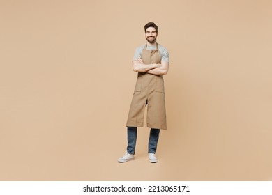 Full body young man barista barman employee wear brown apron work in coffee shop hold hand crossed folded isolated on plain pastel light beige background studio portrait Small business startup concept - Shutterstock ID 2213065171