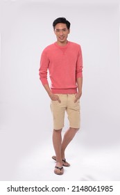 Full Body Young Man Wearing Orange Sweater With Khaki Shorts Standing Posing In Studio