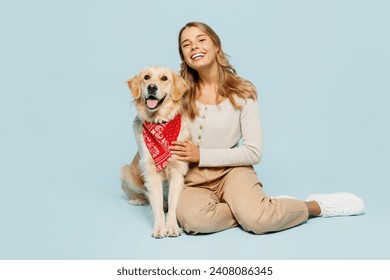 Full body young owner woman wear casual clothes sit hug cuddle embrace look at her best friend retriever dog in red bandana look camera isolated on plain blue background. Take care about pet concept - Powered by Shutterstock