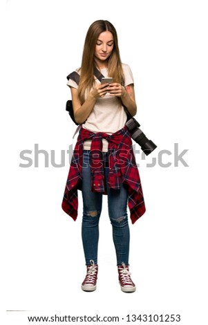Full body Young photographer woman sending a message with the mobile on isolated background