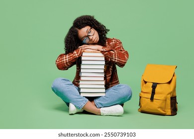 Full body young sad teen girl student wear brown yellow casual clothes backpack bag sits hold put head on pile of books sleep isolated on plain green background. High school university college concept - Powered by Shutterstock